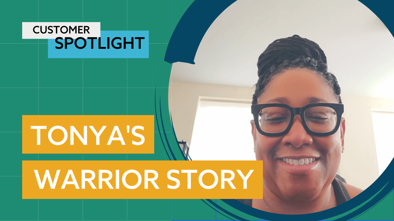 A woman with braided hair and glasses is smiling.