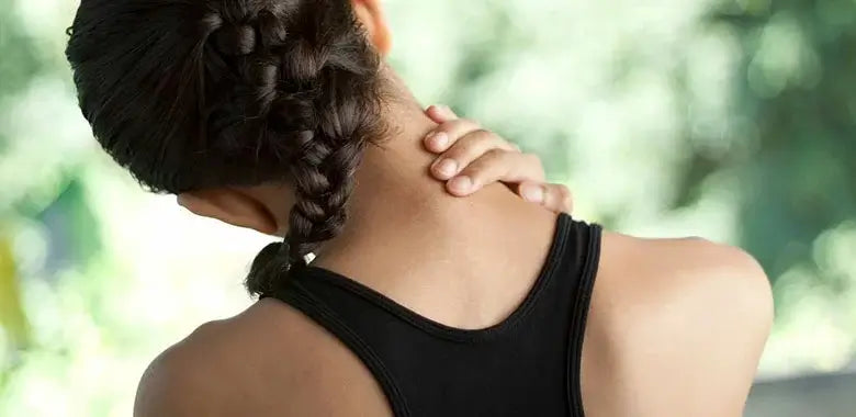 A person with a braid is seen from the back, wearing a black sleeveless top.