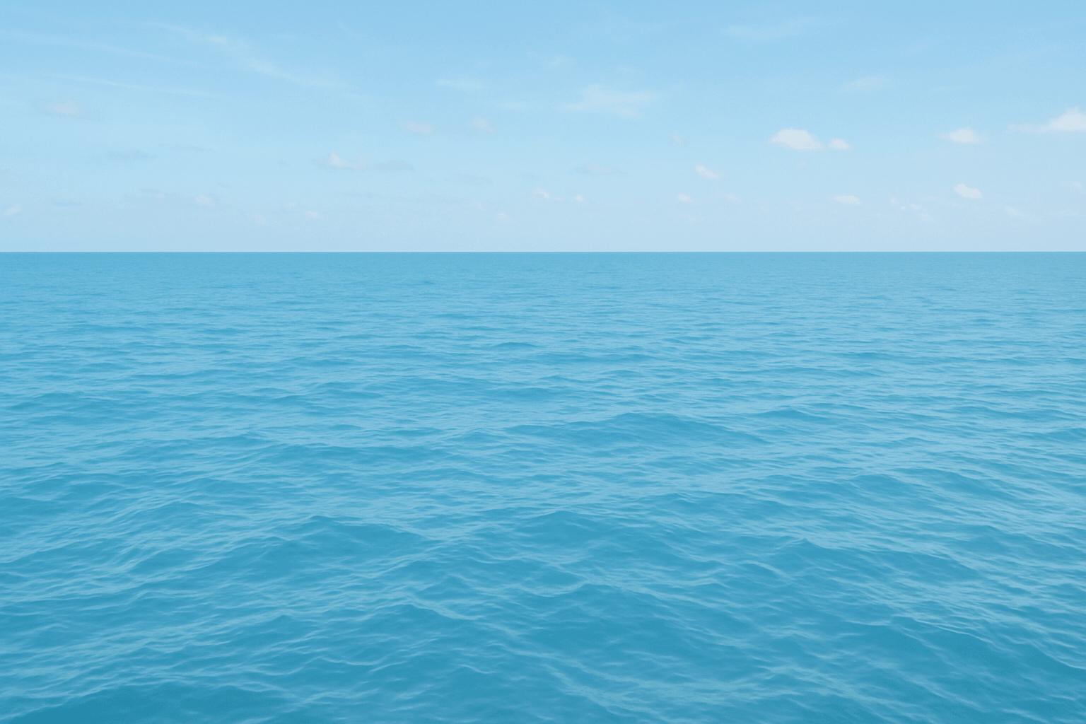 Green serene view of a tranquil ocean under a clear blue sky.