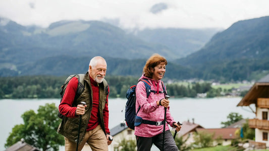 An elderly couple enjoys a hike in a mountainous region.