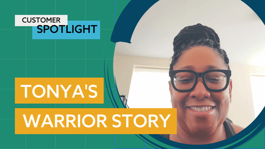 A woman with braided hair and glasses is smiling.