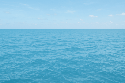 Green serene view of a tranquil ocean under a clear blue sky.