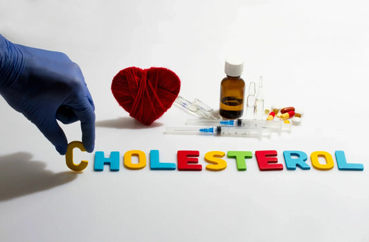 A gloved hand places a "C" next to colorful letters spelling "CHOLESTEROL."
