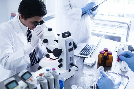 Two scientists in lab coats conduct research in a laboratory.