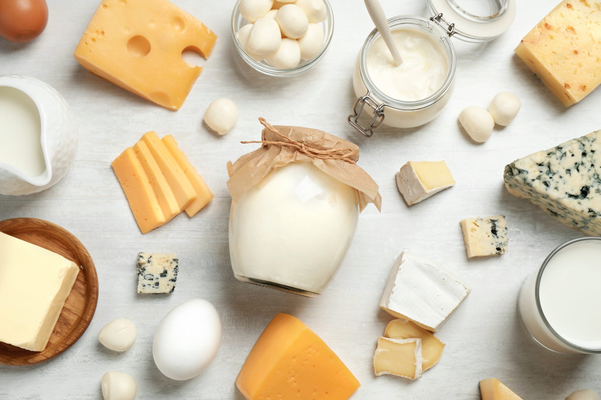 A variety of dairy products arranged on a white surface.