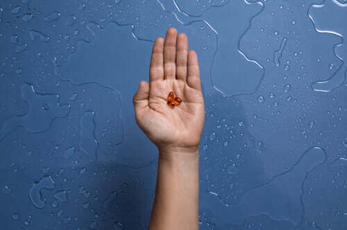 A hand is shown with its palm open against a blue background with water droplets.