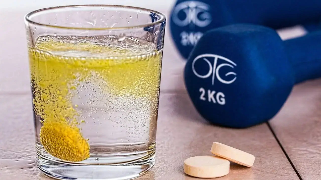 Cushion A dissolving yellow effervescent tablet fizzes in a glass of water next to two more tablets on a table