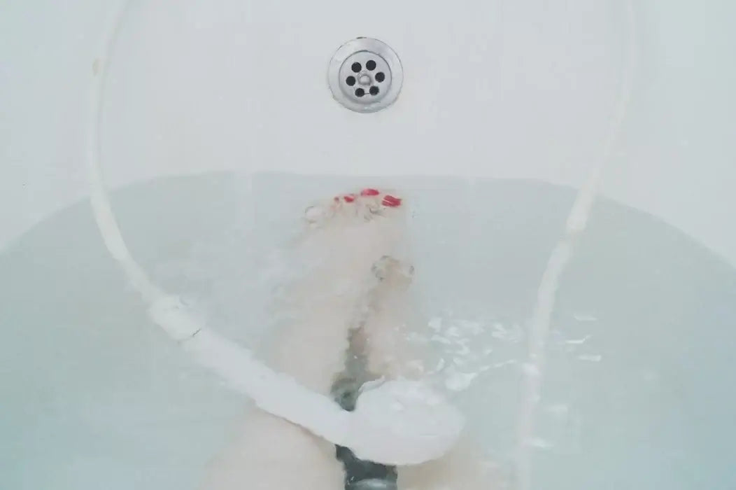 A person is relaxing in a bathtub with water at mid-level.