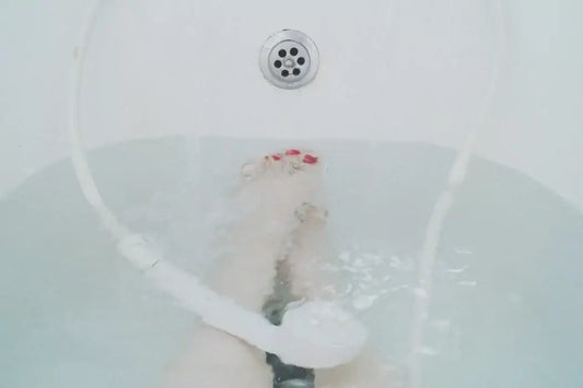 A person is relaxing in a bathtub with water at mid-level.