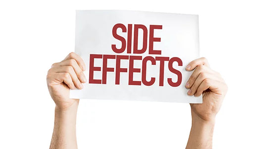 Two hands are holding up a white sign with the words "SIDE EFFECTS" written in bold red capital letters. The background is plain white.