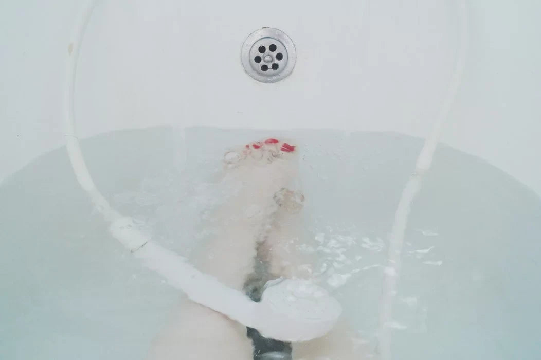 A person is relaxing in a bathtub with water at mid-level.