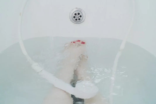 A person is relaxing in a bathtub with water at mid-level.